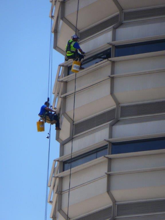 window cleaners repelling down the building