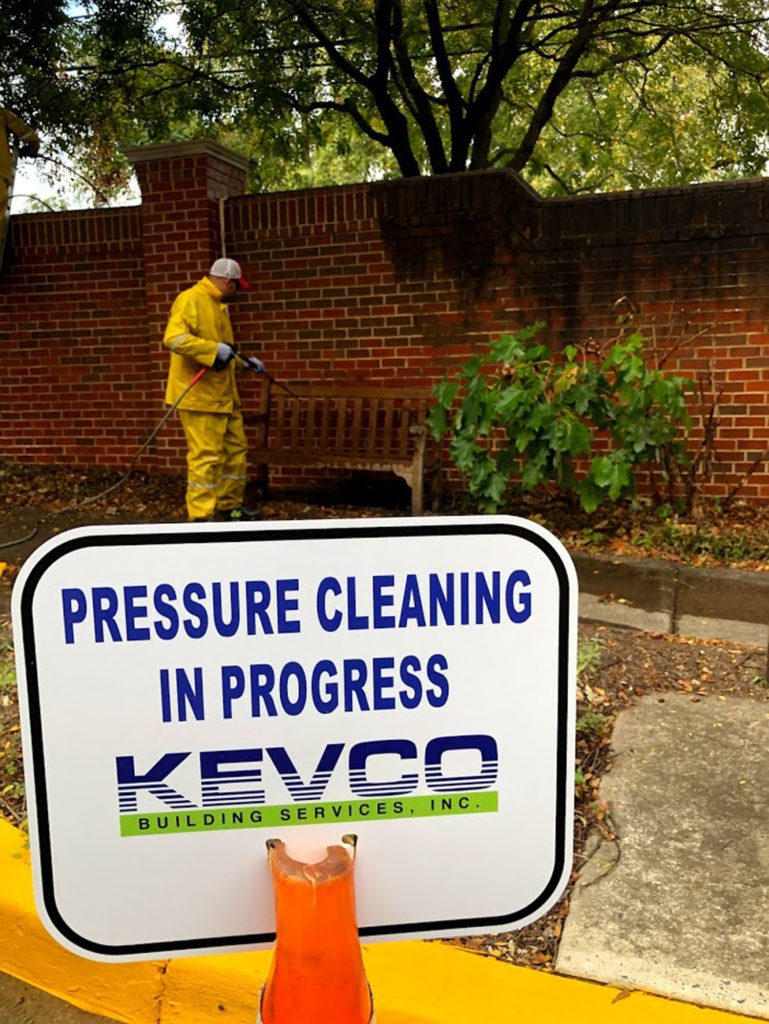 kevco employee pressure cleaning a park bench