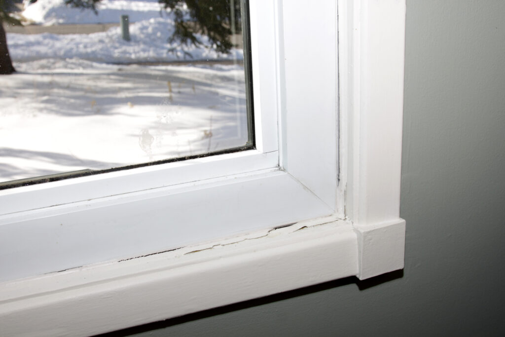 A residential window with damaged caulk